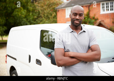 Young black adult tradesman standing next to his white van, close up, close up Stock Photo