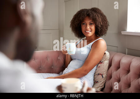 Young mixed race couple relaxing at home in their living room, close up Stock Photo