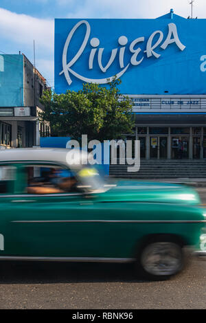 Old American car speeding past the Riviera cinema in Havana, Cuba Stock Photo