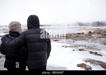 Rear View Of Tourists Visiting Steaming Geothermal Pools In Iceland Stock Photo