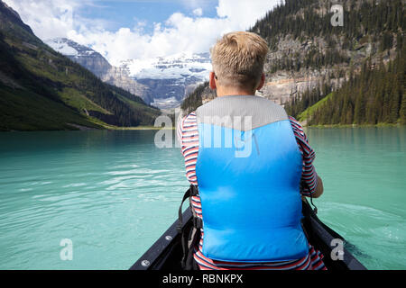 Rear View Of Man Kayaking On Beautiful Lake In Alaska Stock Photo