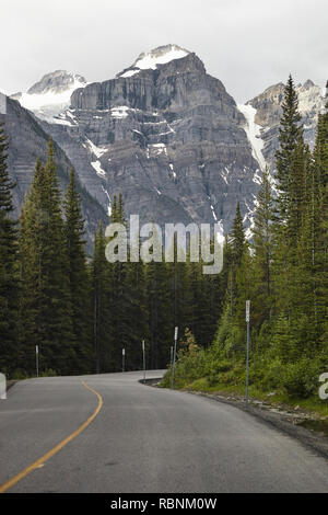 Country Road Through Wooded Valley Between Mountains In Alaska Stock Photo