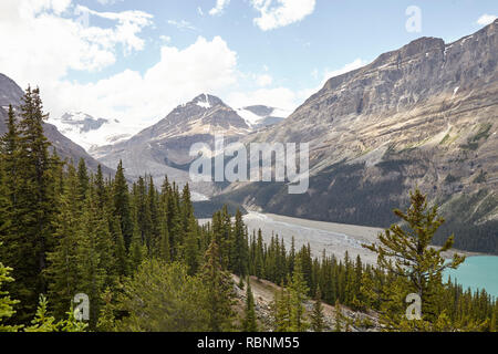 River Running Through Wooded Valley Between Mountains In Alaska Stock Photo