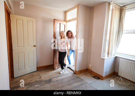 Excited Female Couple Opening Front Door Of New Home Stock Photo