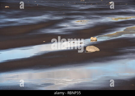 lines of water on the beach with stones Stock Photo