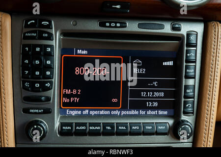 The central control panel of black color with buttons and with red illumination, the included display in a car interior with a console covered with be Stock Photo