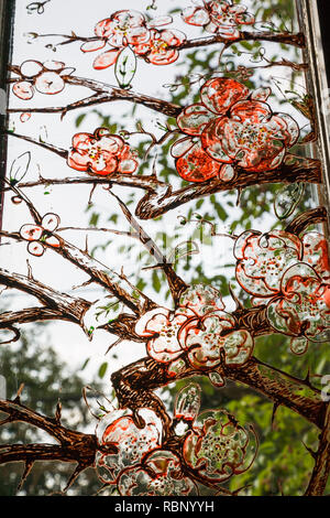 Stained glass tree branches and flower details on front entrance door viewed from inside an old 1862 cottage style home Stock Photo