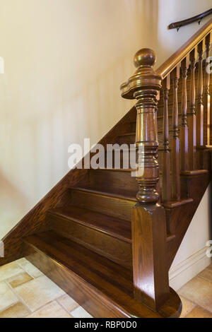 Ceramic tile floor and brown stained oak wood staircase inside a 2006 reproduction of a 16th century Renaissance castle home. Stock Photo