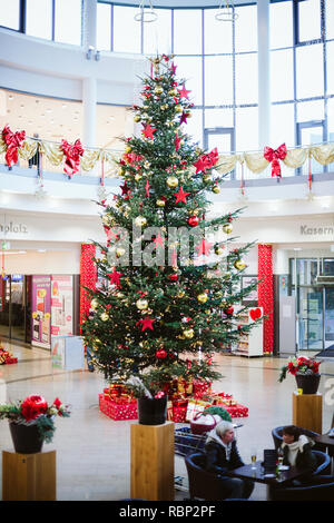FRANKFURT, GERMANY - DEC 21, 2016: majestic Christmas tree in Shopping Center in Frankfurt with people walking during shopping in the mall for gifts for the holidays  Stock Photo