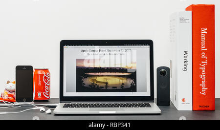PARIS, FRANCE - SEP 3, 2017: Minimalist creative room table with Safari Browser open on MacPook Pro laptop showcasing Apple Computers website with latest iPhone X 10 and Steve Jobs Theatre  Stock Photo