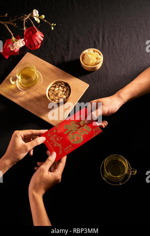 Chinese Lunar New Year concept red envelope with Chinese character means happiness or good fortune, the chinese sentence means “Wishing you prosperity Stock Photo