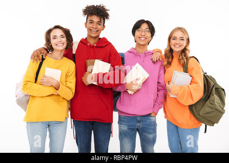 Photo of emotional young group of friends students standing isolated over white wall background posing. Stock Photo