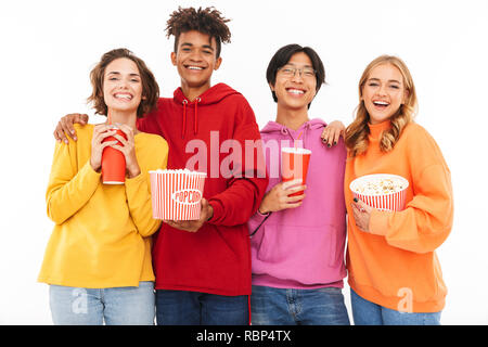 Group of cheerful multiracial friends watching a movie, eating popcorn, drinking soda isolated over white Stock Photo