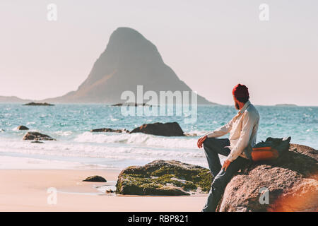 Man relaxing alone on ocean beach summer vacations traveling tourist lifestyle adventure journey outdoor in Norway Stock Photo