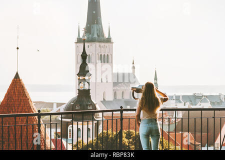 Young woman traveling in Tallinn city vacations in Estonia weekend Lifestyle outdoor girl tourist sightseeing St Olav's Church Old Town architecture Stock Photo