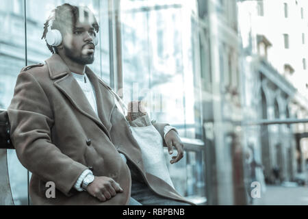 Frustrated young man listening to music in headphones Stock Photo