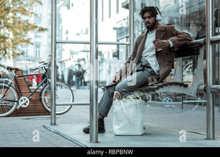 Serious international man wearing headphones during walk Stock Photo