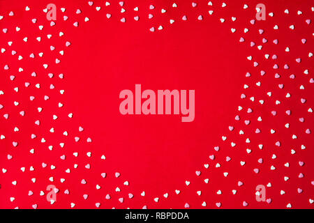 Heart shape made with heart candy on red background for Valentine's Day. Copyspace Stock Photo