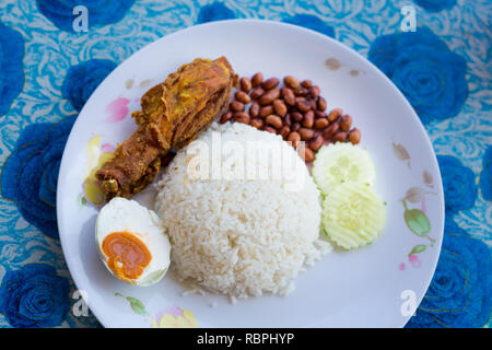 Fresh prepared malaysia nasi lemak set dish served with salted egg in local restaurant on Langkawi island. Traditional asian cuisine made of fresh ing Stock Photo