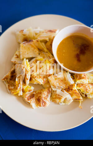 Fresh prepared Malaysian roti telur with egg served with lentil dahl in local restaurant on Langkawi island. Traditional asian cuisine made of fresh i Stock Photo
