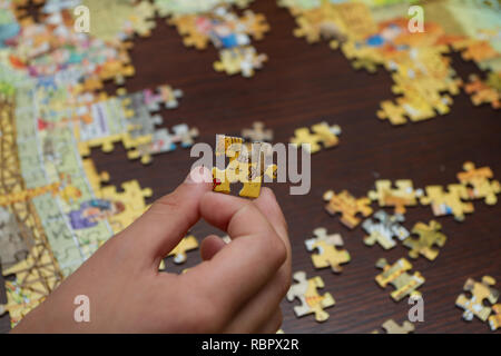 Boy's hand holding one a puzzle piece Stock Photo