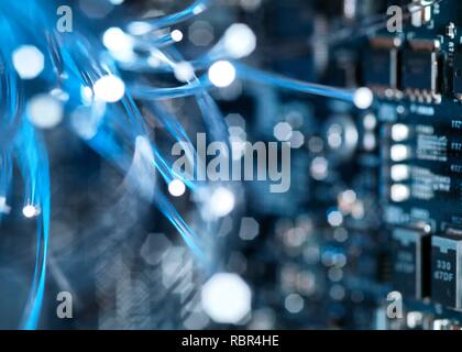 Fibre optics carrying data over electronic circuitry on a laptop computer. Stock Photo