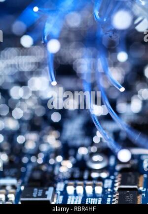 Fibre optics carrying data over electronic circuitry on a laptop computer. Stock Photo