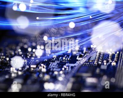 Fibre optics carrying data over electronic circuitry on a laptop computer. Stock Photo