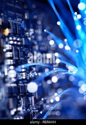 Fibre optics carrying data over electronic circuitry on a laptop computer. Stock Photo