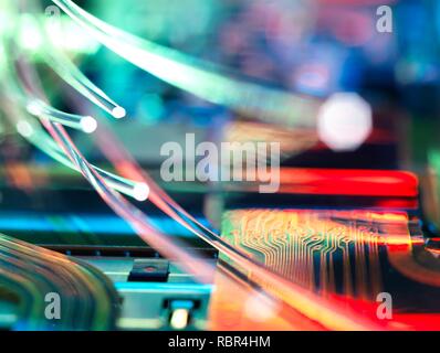 Fibre optics carrying data over electronic circuitry on a laptop computer. Stock Photo