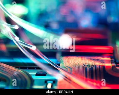 Fibre optics carrying data over electronic circuitry on a laptop computer. Stock Photo