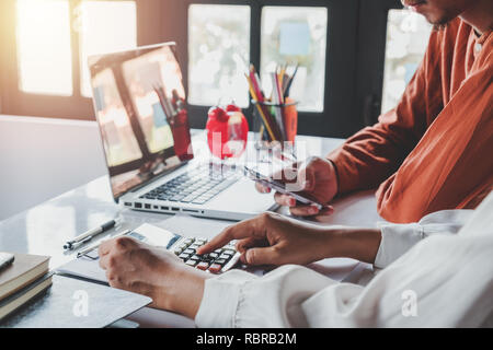 Business project team working together at meeting room at office an using calculator and smart phone for discussing data.Business team analysis and st Stock Photo