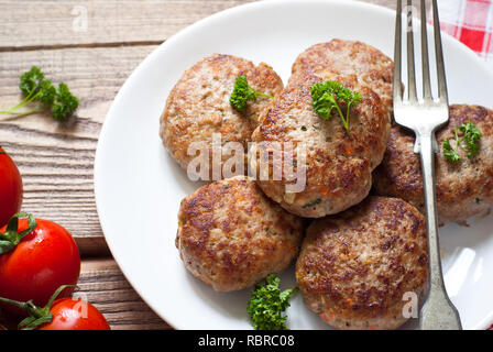 Fresh fried cutlets in a white plate on wooden table. Stock Photo