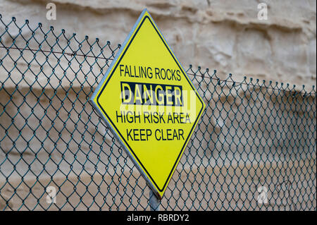 Falling Rocks, Danger, High Risk Area, Keep Clear, warning sign on a fence. Stock Photo