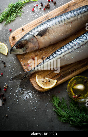 Fresh fish. Raw mackerel with salt, lemon and spices on a dark background. Stock Photo