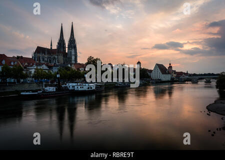 There is Saint Peter cathedral in Regensburg, Bavaria, Germany. Cityscape image over the Danube river during sunset. Stock Photo