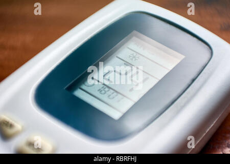 The remote control of an air conditioner set to 24 degrees celsius, a recommended setting to protect the environment. Stock Photo