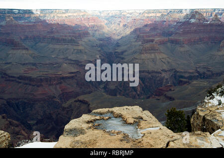 The South Rim Trail of the Grand Canyon offers excellent views of the canyon, but winter ice can make areas slippery. Stock Photo