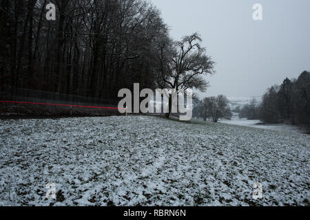 wintry road with light trails from cars Stock Photo