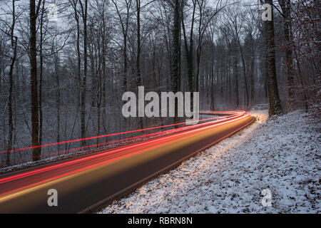 wintry road with light trails from cars Stock Photo