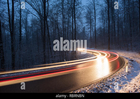 wintry road with light trails from cars Stock Photo