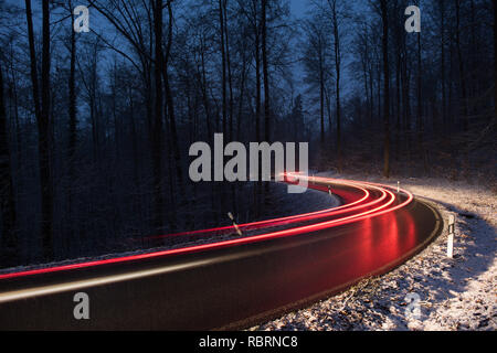 wintry road with light trails from cars Stock Photo
