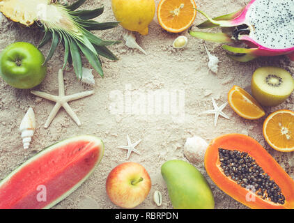 Group of fruits on sand background with shells.Top view Stock Photo