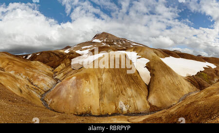 Panorama of a wide dark stone landscape in the background with a mountain range glowing in the evening light - Location: Iceland, highlands, Bergland  Stock Photo