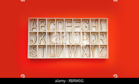 Wooden alphabet blocks with letters - box on a red background. Concept of learning english Stock Photo