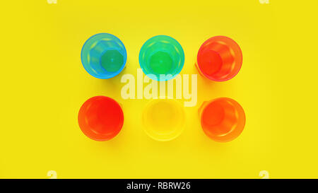 Plastic glass of various color isolated on yellow background - bright summer concept for design and banners Stock Photo