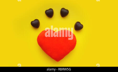 Valentines day background with soft toy heart and chocolates on yellow background. Top view. For banner, cards design Stock Photo