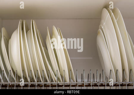 Dish drying metal rack with big nice white clean kitchenware. Traditional  wall cabinet kitchen Stock Photo by Vladdeep