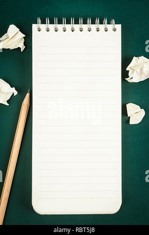 Open blank diary notebook with wooden pencil on green board for your text or message. Stock Photo