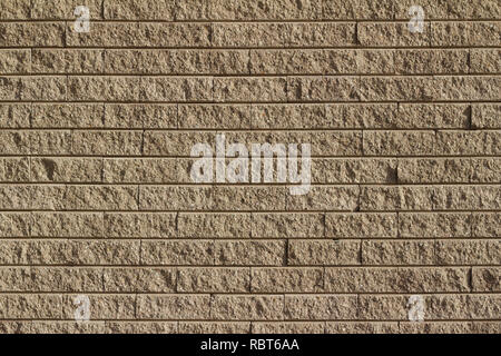 Light brown tan colored rough textured stone brick wall abstract background Stock Photo